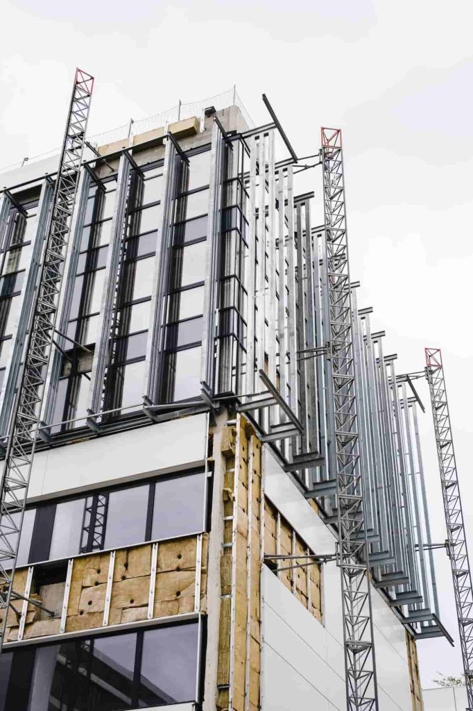 A partially constructed building with visible insulation and steel beams, documented using 3D laser scanning to capture intricate structural details for modeling.