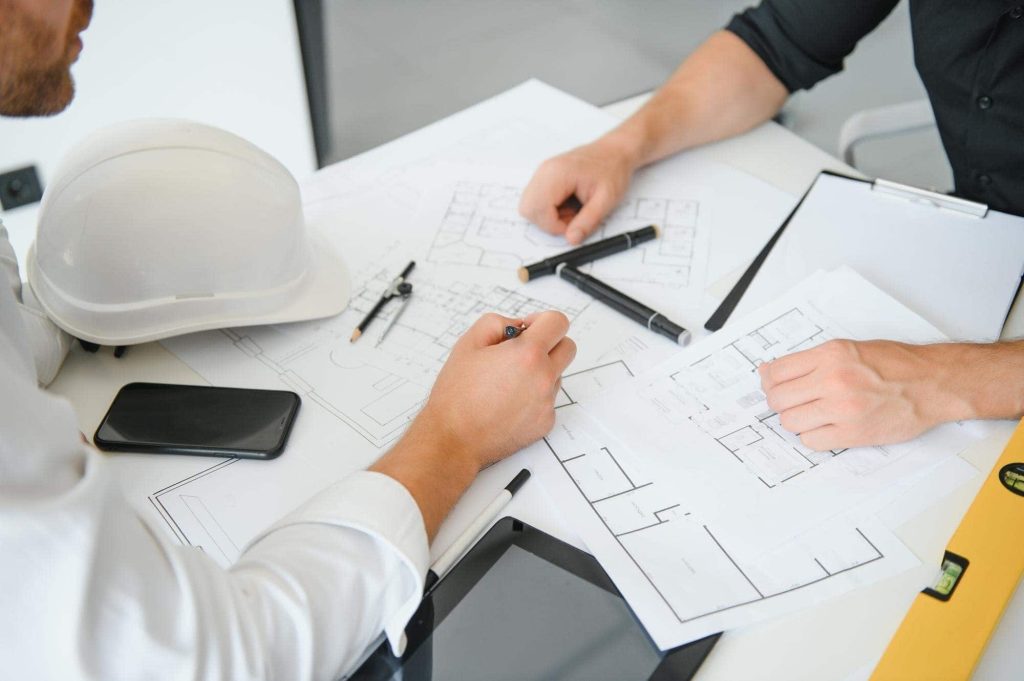 Architects reviewing as-built plans for commercial property development.