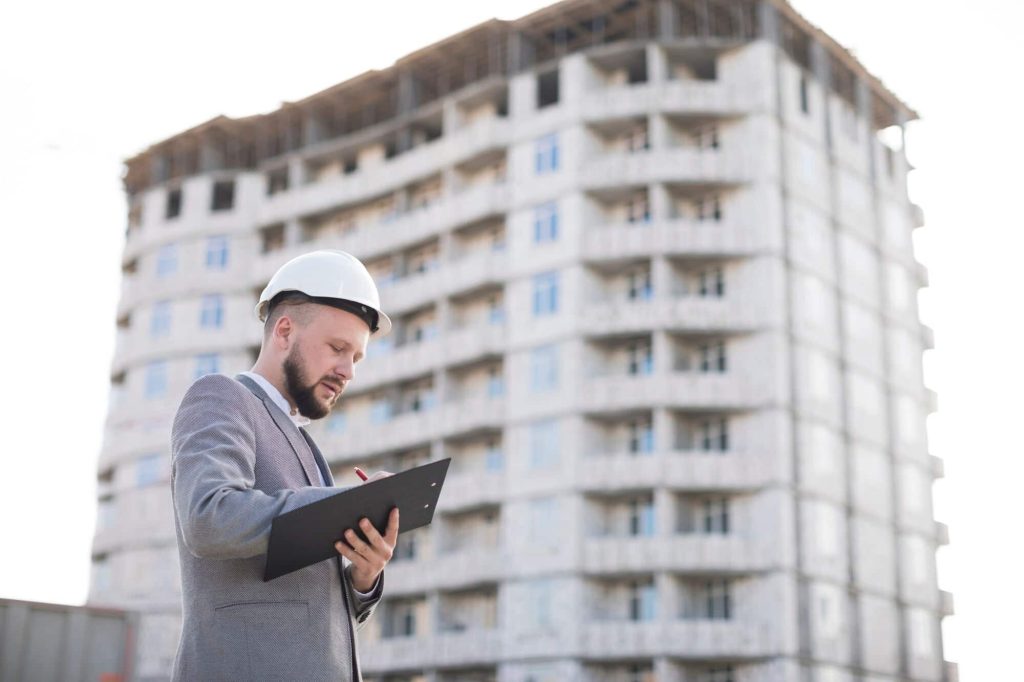 Engineer conducting a building inspection with structural analysis in progress.