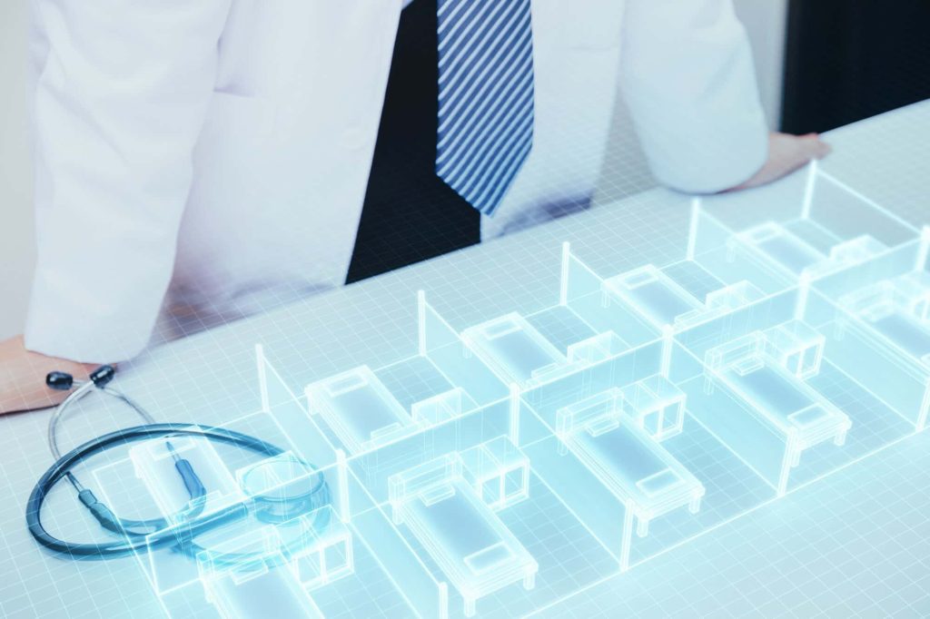 Medical professional reviewing a digital 3D model of a healthcare facility layout, emphasizing precise As-Built services for hospital renovation and compliance planning.