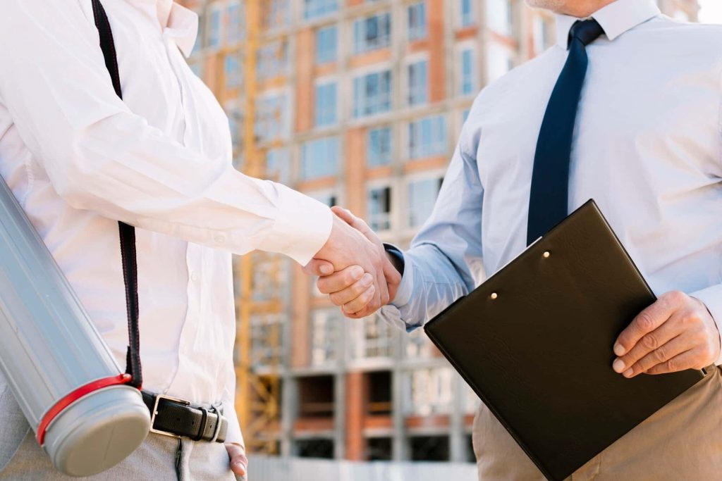 Business handshake on a construction site, symbolizing collaboration and efficiency with laser 3D scanning technology.