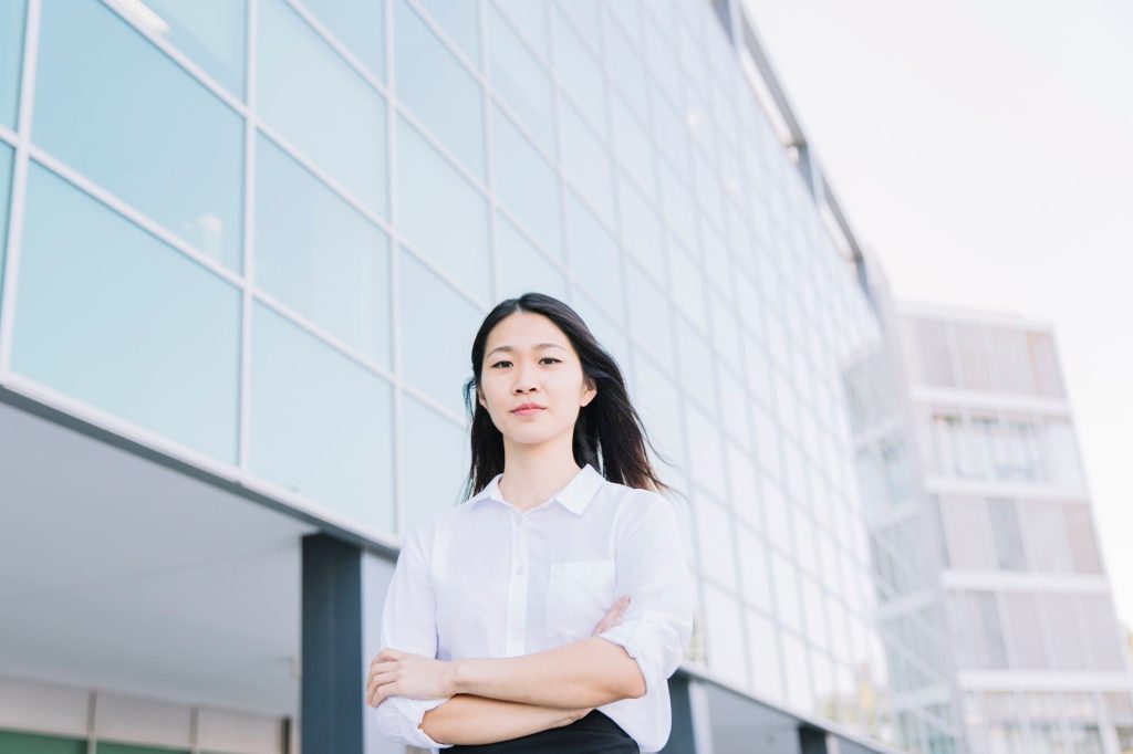 Urban planner standing confidently in front of a modern building, representing municipal authorities involved in facade restoration projects.