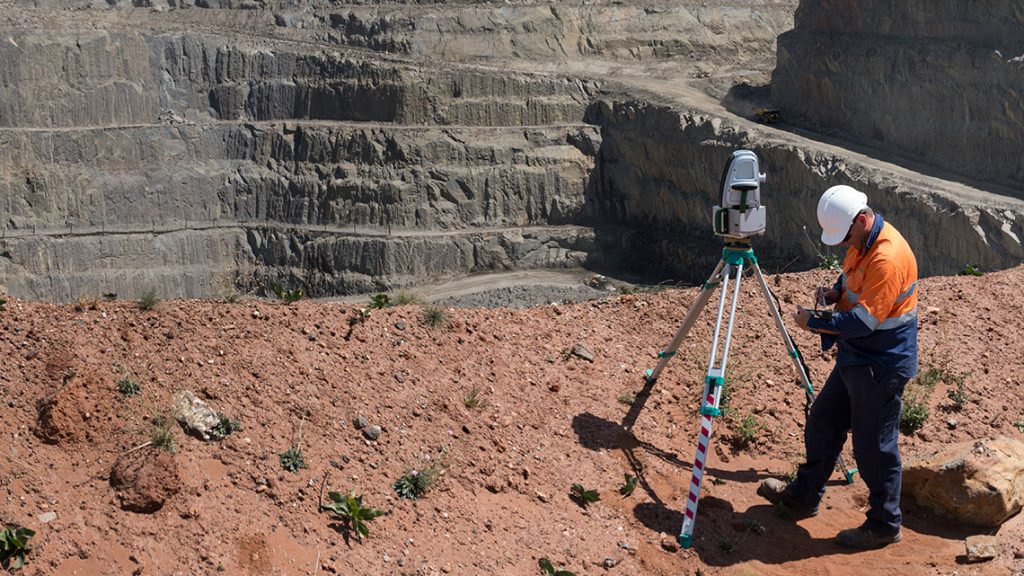 Active open-pit quarry with heavy machinery and stepped terrain